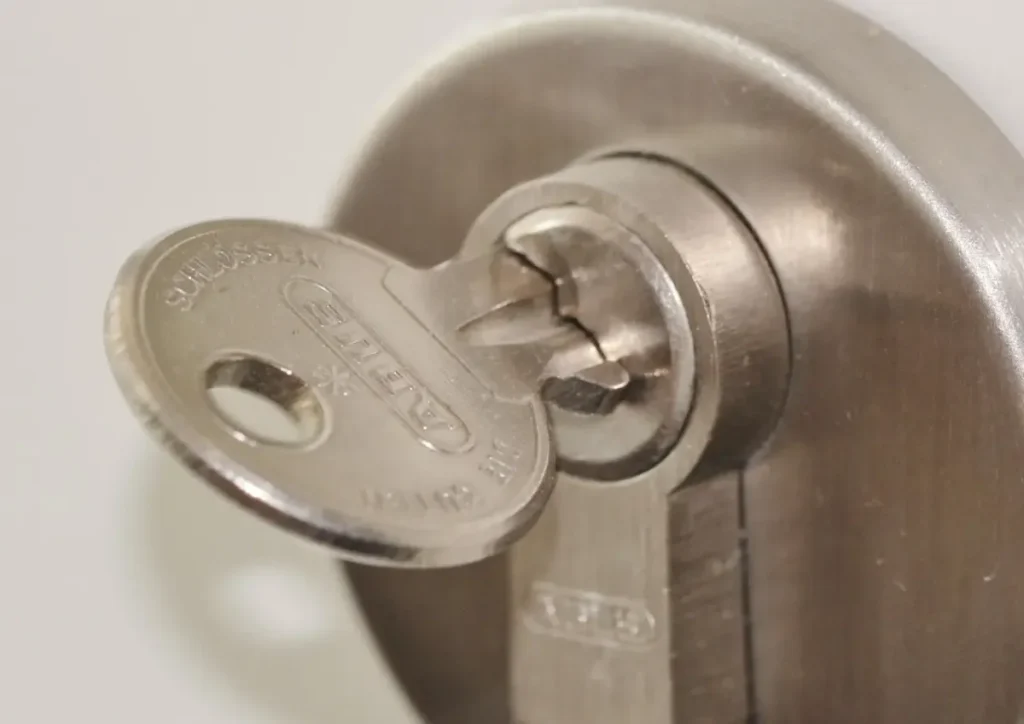 Key inserted in a door lock cylinder – how to choose a trustworthy locksmith in Lancing before a lock is drilled or replaced, Locksmith Lancing